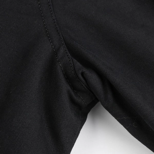 Detailed close-up of heavy-duty black twill fabric with reinforced stitching on jacket