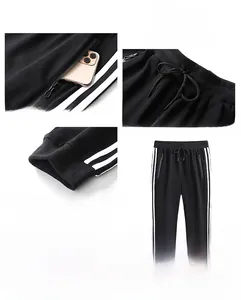 Detail view of black sports joggers featuring classic white side stripes and elastic waist