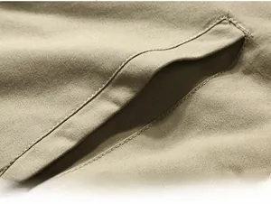 Detailed view of the large side pocket on a khaki workwear jacket with reinforced stitching