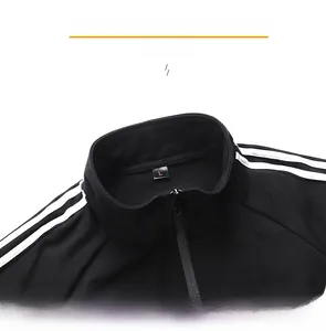 Detail view of the stand-up collar and zipper on this black cotton tracksuit jacket