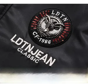 Detail of embroidered chest badge with metal goat head and red sequins on men's jacket