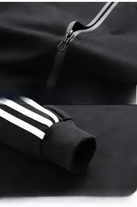 Detail of waterproof zipper and elastic ribbed cuffs with three white parallel stripes