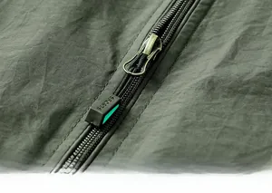 Gros plan détaillé sur la fermeture éclair et le tissu texturé du gilet extérieur