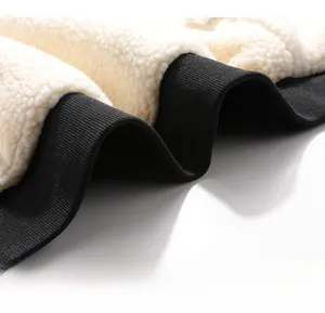 Close-up of the ribbed black hem and soft white sherpa fleece fabric of the jacket