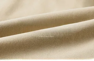 Gros plan de la texture du tissu en coton beige montrant le tissage doux et le matériau chaud
