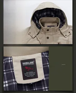 Detail of khaki jacket with plaid lining, brand label, and metal snap button closure
