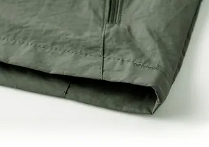 Gros plan détaillé de l'ourlet à double couture sur un gilet tactique outdoor vert olive