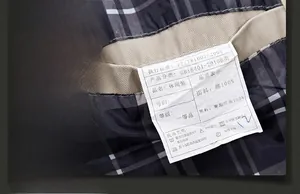 Detail view of cotton jacket lining with black-white plaid pattern and fabric care label