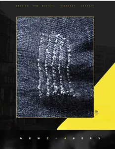 Detailed close-up of dark blue denim fabric with distressed ripped and worn details