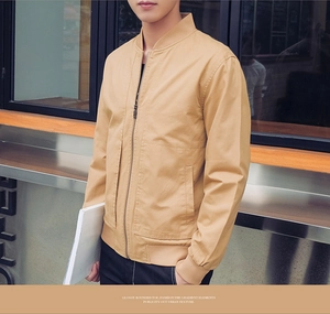 Detail of khaki cotton bomber jacket with standing collar and ribbed cuffs in urban setting