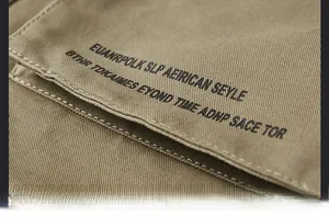 Close-up detail of letter print on khaki twill jacket pocket with precise stitching