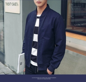 Detail of navy blue cotton jacket featuring a classic stand collar and ribbed cuffs