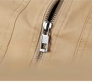 Detail of premium silver metal zipper on khaki cotton jacket with reinforced stitching
