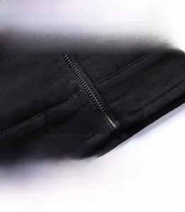 Detail of the metal zipper and precise double-stitching on a black woven cotton jacket