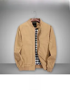 Detail view of khaki cotton bomber jacket with black and white checkered lining on hanger