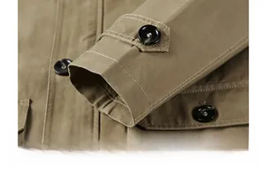 Détail du poignet d'une veste kaki avec des surpiqûres blanches contrastées et des boutons
