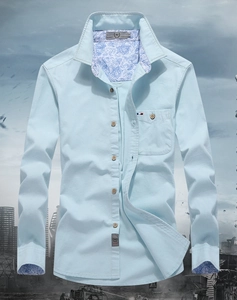 Detail of light blue shirt collar with paisley lining, wooden buttons and tri-color tab