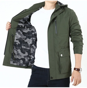 Detail of olive green hooded jacket featuring camouflage lining and multi-pocket utility design