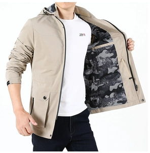 Detail of khaki windbreaker showing camo lining, drawstring hood, and utility cargo pocket