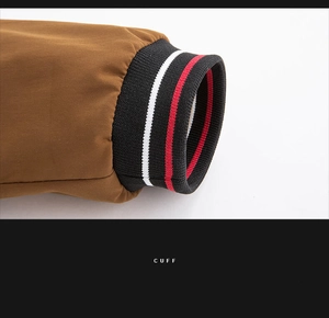 Detail of a brown jacket cuff with black ribbed knit and red and white stripes