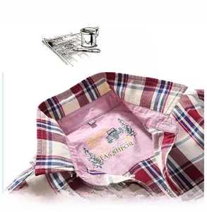 Detail of the shirt collar with navy, red and cream plaid pattern and cotton texture