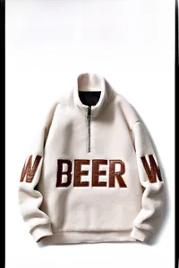 Détail du sweat en polaire sherpa crème avec écusson BEER marron et col à demi-fermeture