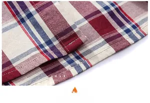 Detail of double-stitched hem on a red, white, and blue plaid cotton shirt