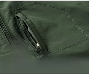 Detailed close-up of a men's warm jacket showing hidden zipper pocket and fine stitching