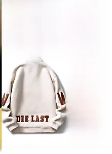 Détail de la veste en laine d'agneau blanche montrant la broderie et la fermeture