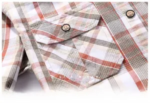 Detail of vintage orange plaid shirt showing cotton texture and buttoned chest pocket
