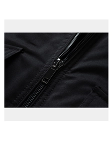 Detail of a black tactical jacket featuring a premium metal zipper and reinforced pocket flap