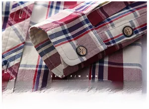 Detail of red and blue plaid shirt cuffs with wood-style buttons and fine stitching