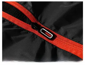 Dettaglio della giacca outdoor in tessuto ripstop nero e cerniera rossa a contrasto