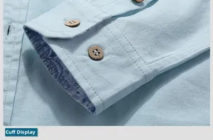 Detail of light blue linen shirt cuff with wood buttons and blue paisley lining