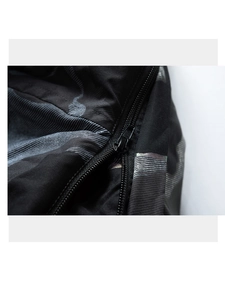 Detailed macro view of heavy-duty black metal zipper on camo patterned fabric