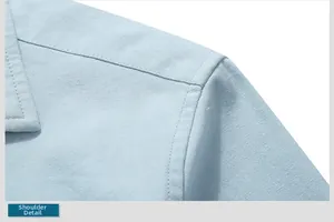 Detailed macro view showing the shoulder seam and woven texture of the blue cotton shirt