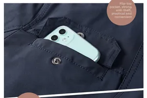 Detailed view of dark blue jacket flap pocket with metal snap button and smartphone inside
