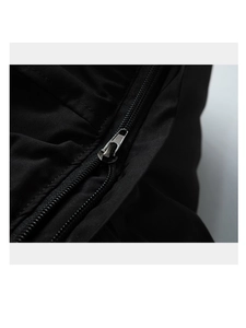 Détail du tissu noir tissé et fermeture éclair en métal mat sur la veste d'hiver