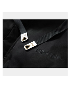 Détail macro du manteau noir avec embouts de cordon H-S et broderie EX3-ARMY sur le tissu