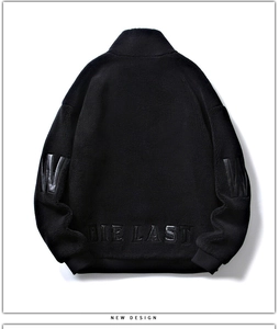 Détail d'une veste en polaire noire avec lettrage en cuir embossé sur l'ourlet arrière