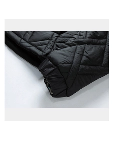 Detail of black diamond quilted jacket cuff with elastic hem and colorful plaid lining