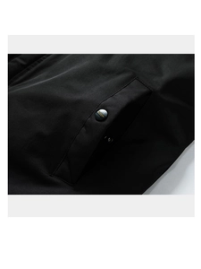 Détail de la poche de veste d'hiver avec bouton-pression noir et tissu tissé texturé