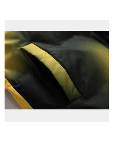 Détail macro de la poche matelassée à dégradé jaune et noir sur une veste d'hiver