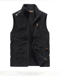Detail van zwart fleece vest met ritszakken en opvallende oranje trekkers