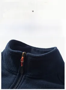 Detail van de opstaande kraag en rits met oranje trekker op de blauwe fleece bodywarmer