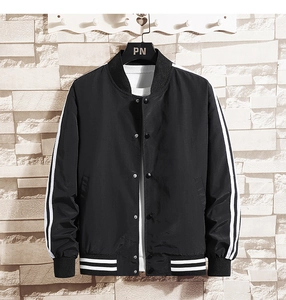 Detail of black baseball jacket featuring white striped collar and snap button closure