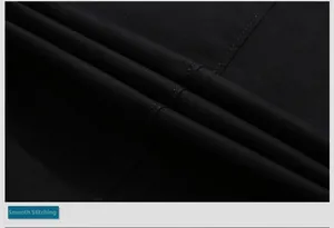 Macro detail of neat stitching and diagonal twill texture on a black business blazer