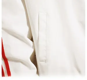 Detail of white baseball jacket featuring large capacity pocket and red ribbon stripe