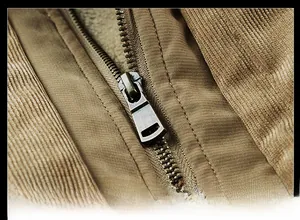 Close-up of a durable antique bronze metal zipper on a brown corduroy winter coat