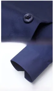 Detail view of navy blue dress shirt showing clean placket stitching and buttoned cuffs